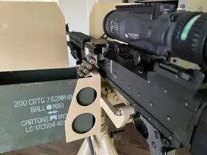 Belt-fed 7.62mm machine gun with magnified optic on a tripod