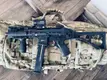 Suppressed compact rifle with red dot on a plate carrier